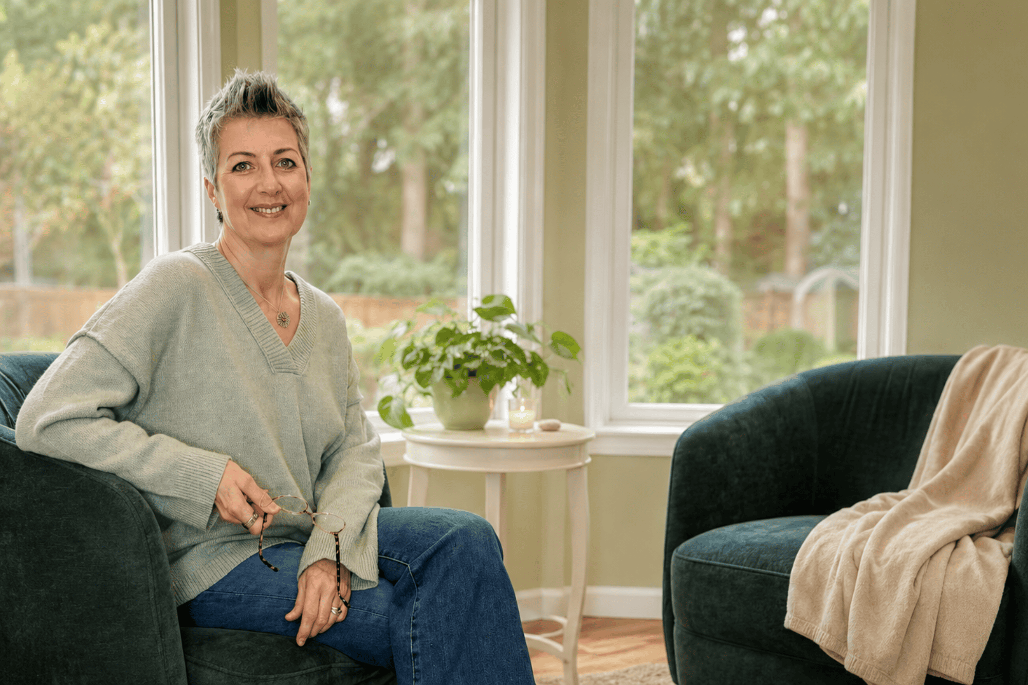 Georgie Coote seated in a cozy coaching space beside an empty green armchair.